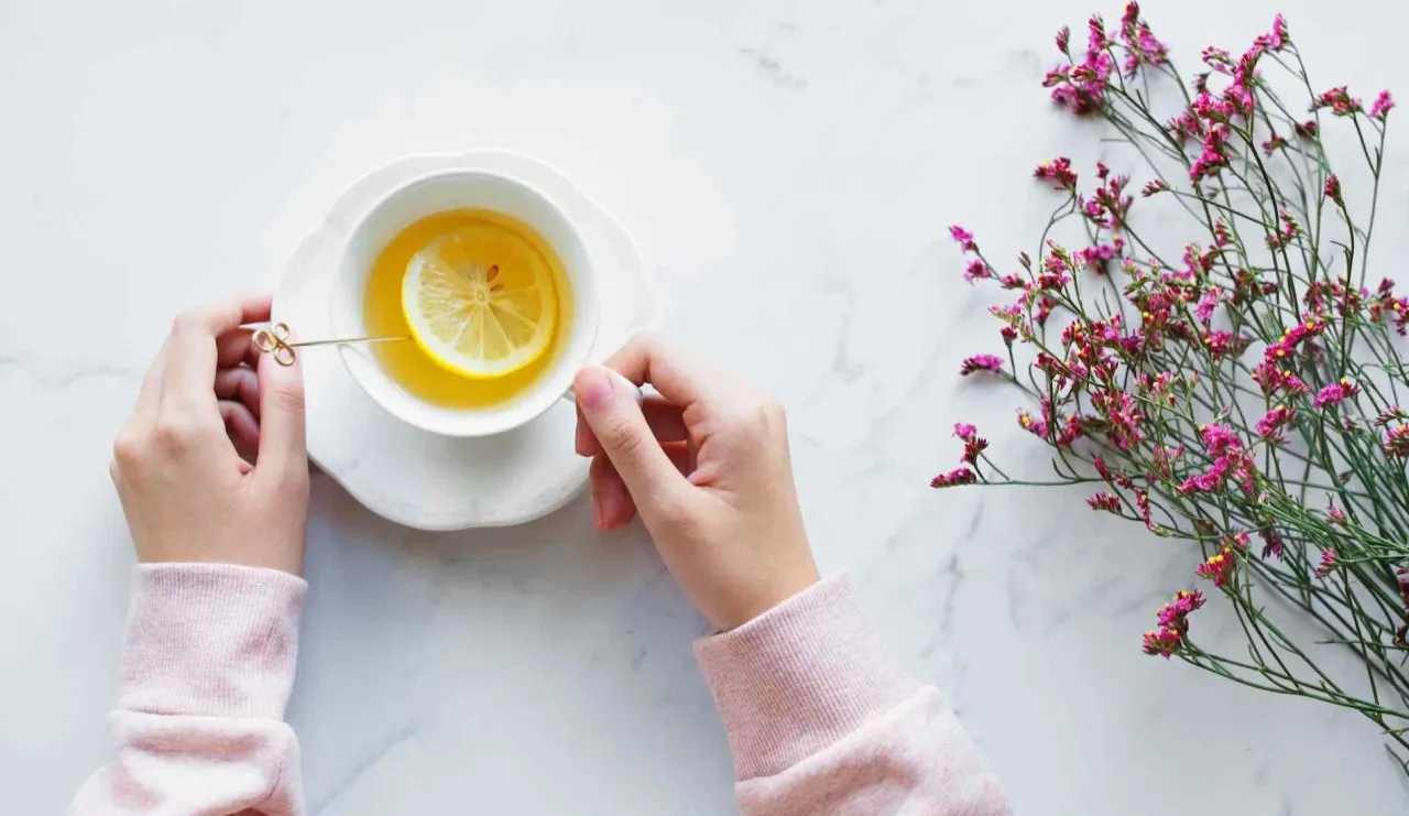 girl with cup of hot lemon water