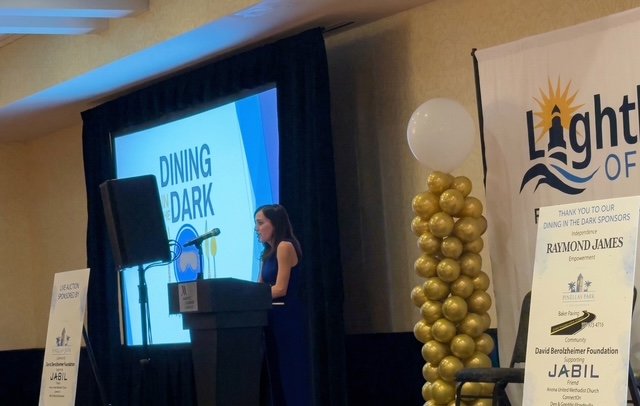 Marisa D'Amore speaking at Lighthouse of Pinellas Dining in the Dark in March 2026