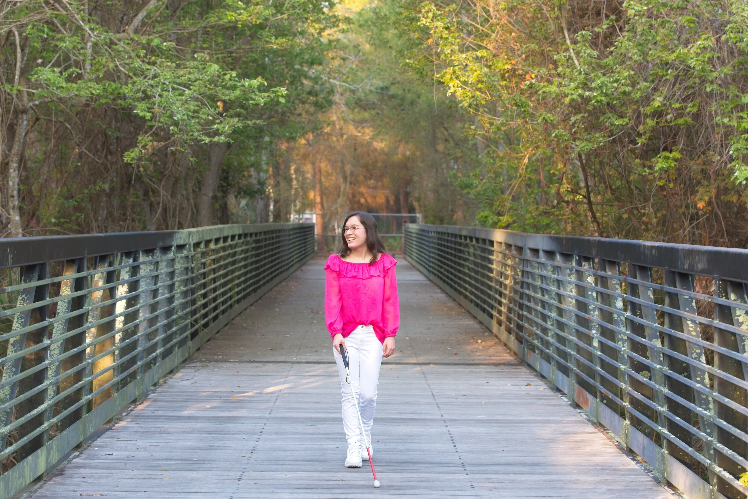 Marisa D'Amore walking across a bridge with her white cane