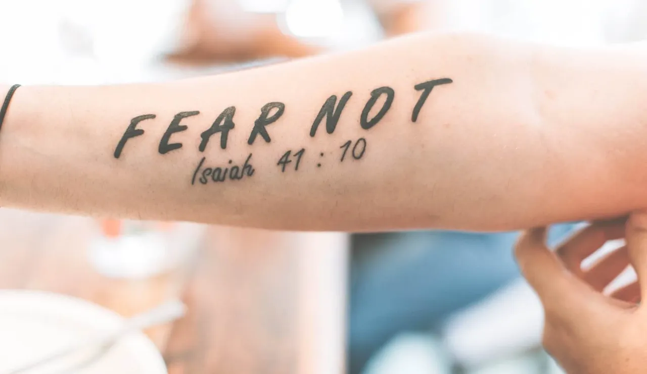 man's forearm tattoo with text that says 'Fear Not' Isaiah 41:10